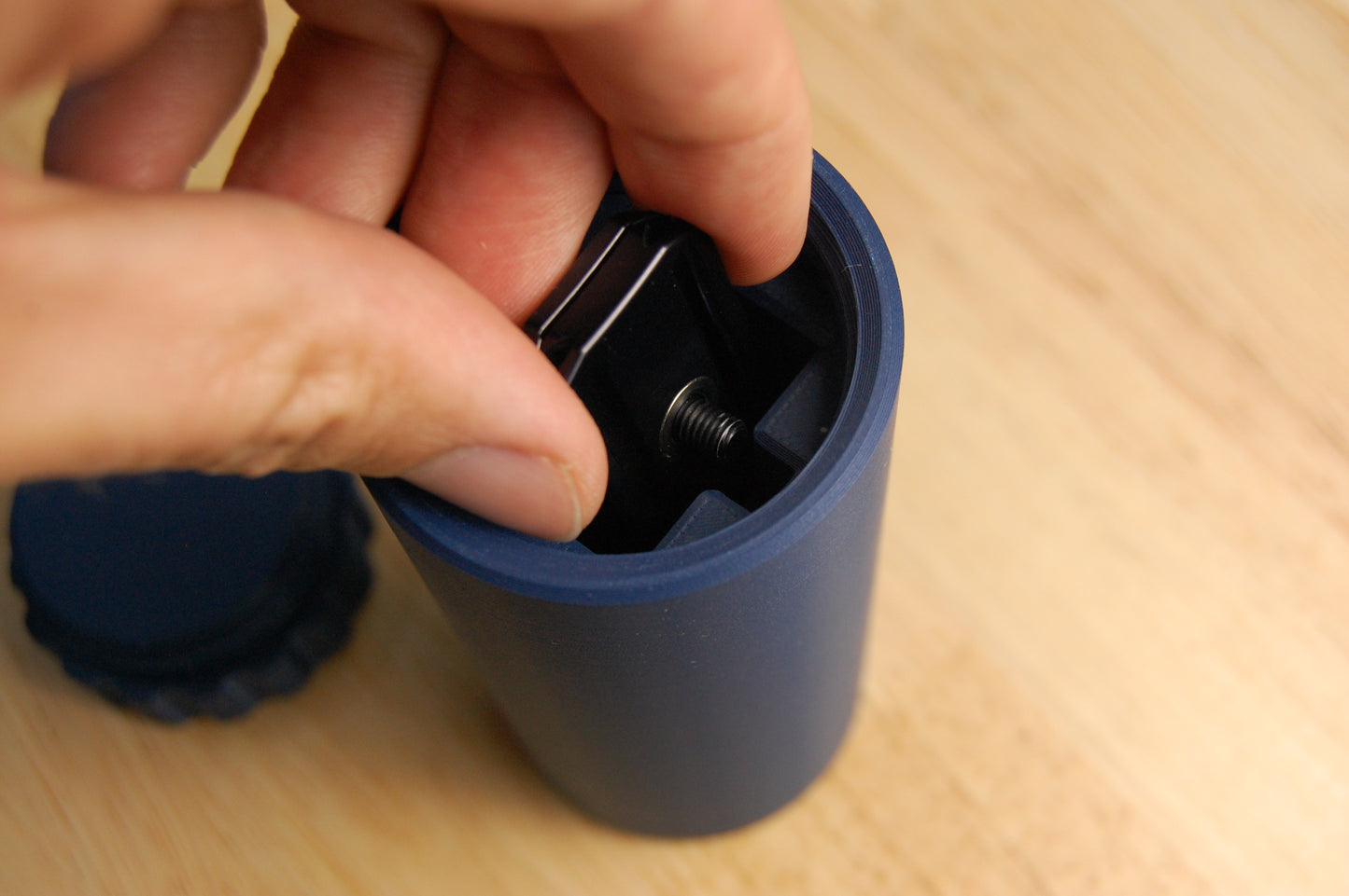 Inserting black razor head into a navy blue suborbital capsule.