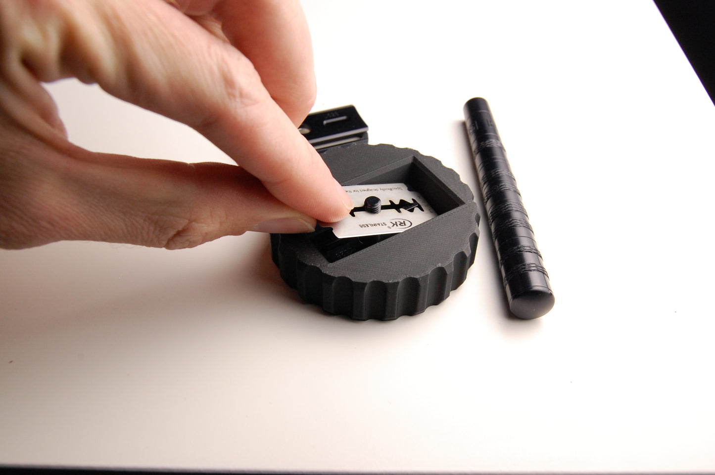 Close usage shot of the Henson Blade Installation and Removal Tool.  Installing the double edged razor blade into the tool.