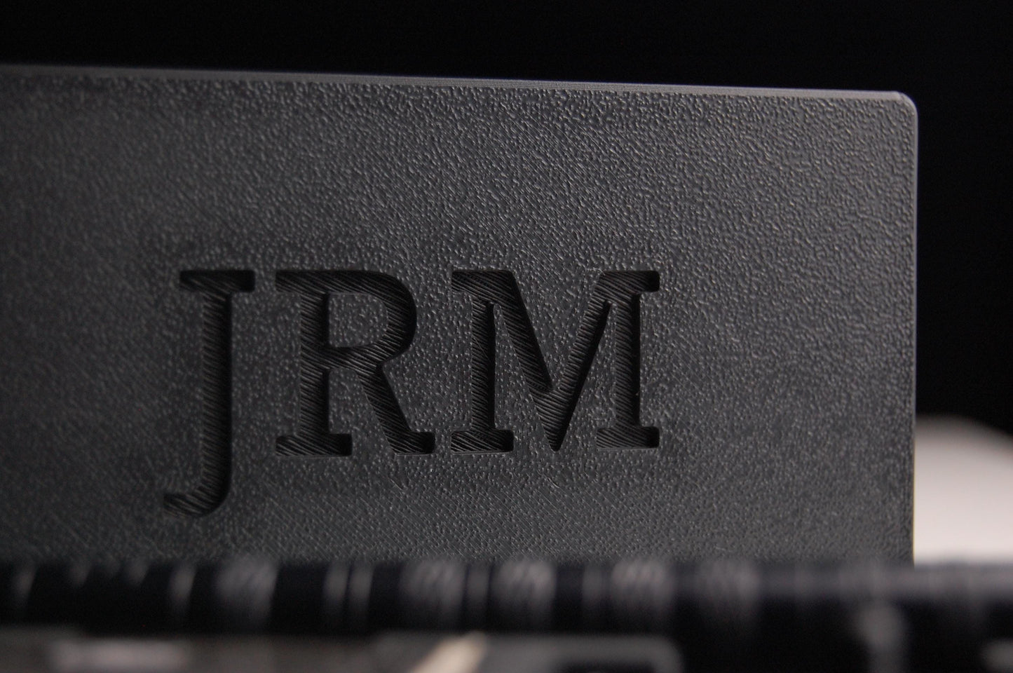 Henson razor travel case close up on a black background .  The letters "JRM" are  on the case lid.  The razor and spare blades are in the case.