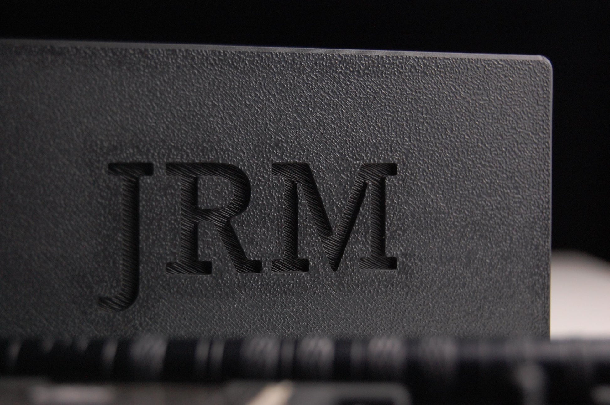 Henson razor travel case close up on a black background .  The letters "JRM" are  on the case lid.  The razor and spare blades are in the case.