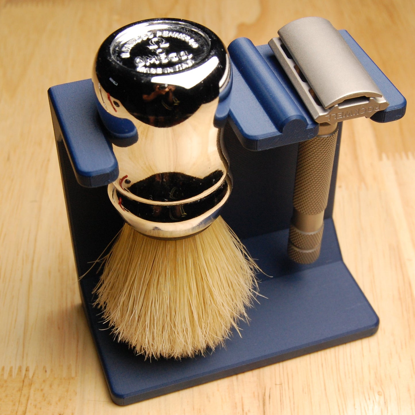 Shaving brush, Rockwell 6s razor, and stand on a wooden surface