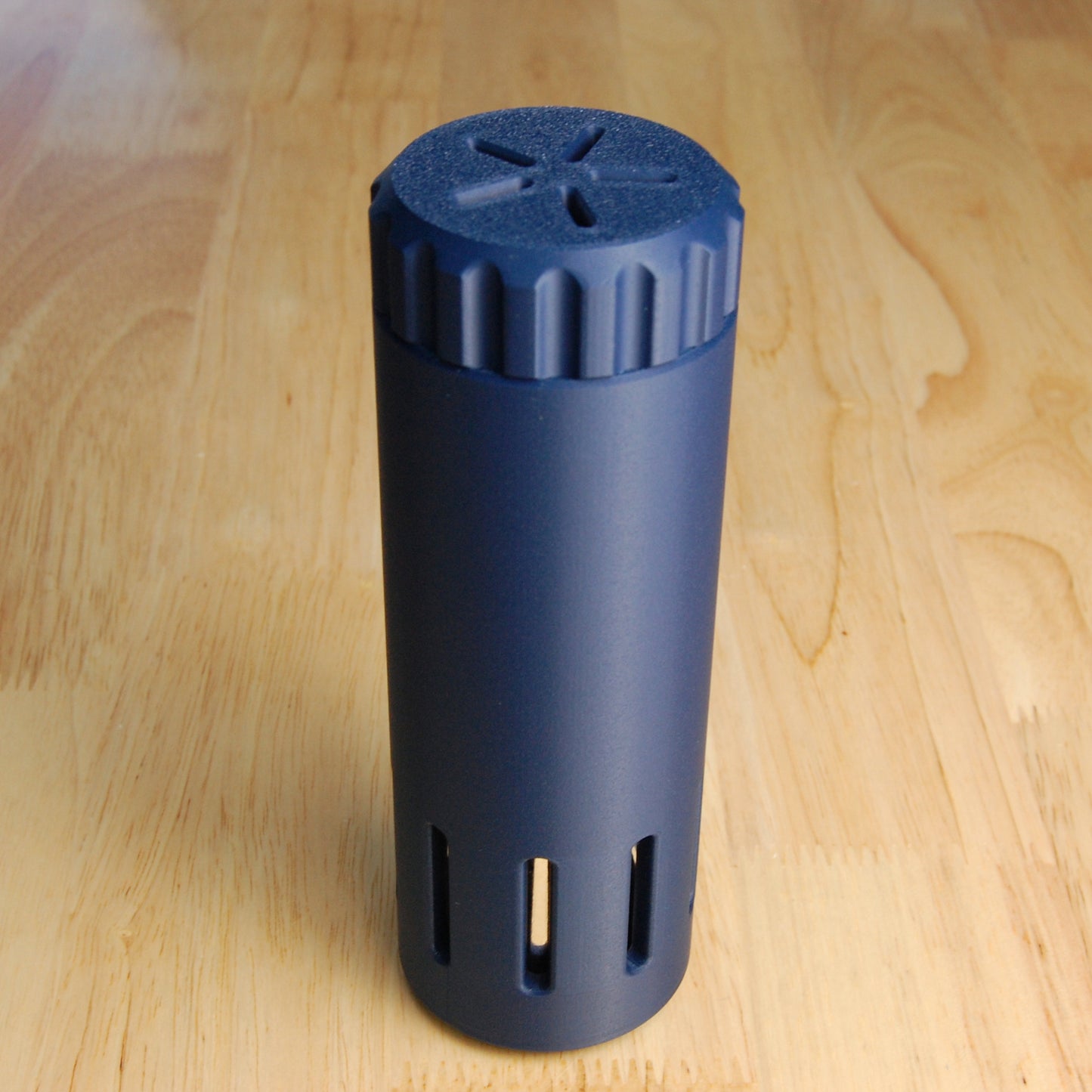 Navy blue vented capsule shaving brush case on a wooden background