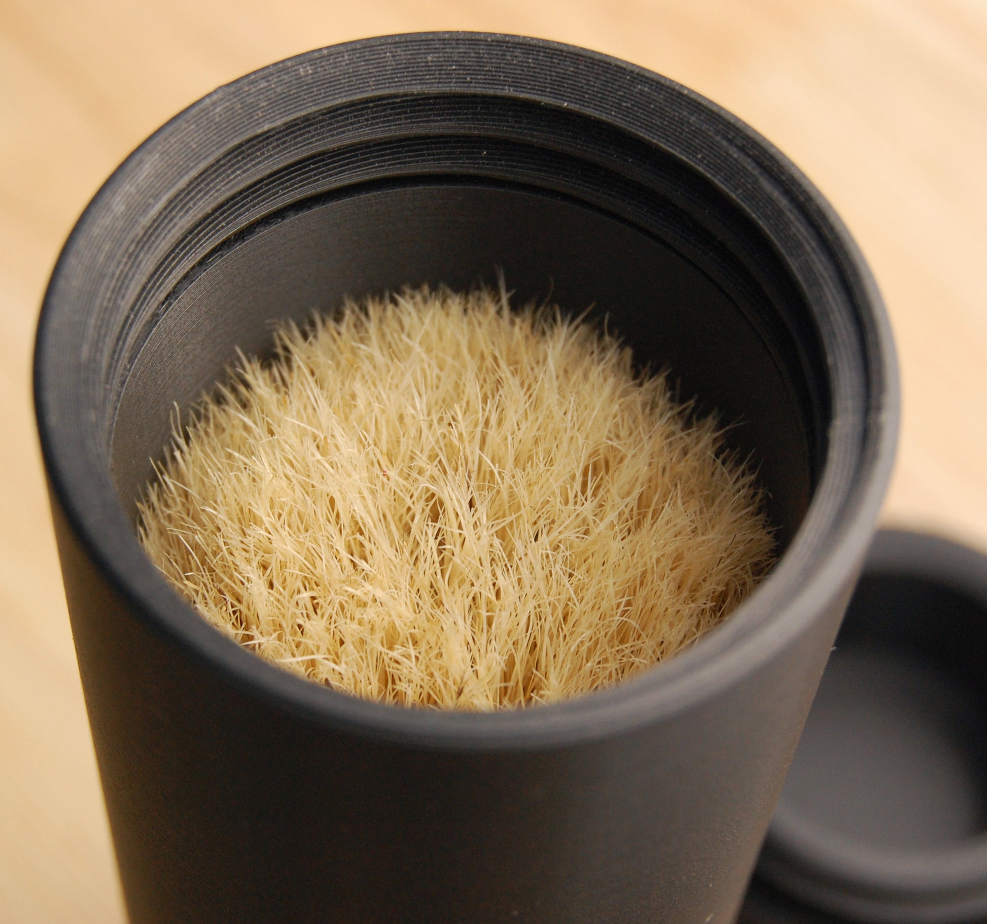 Shaving brush in a black capsule brush case.