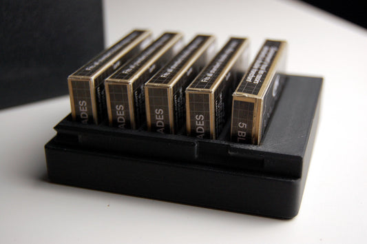Black Double Edge Razor Blade box open on a white table. Close up view to show the details of the box.  This version holds 5 razor blade boxes.  5 RK razor blades are in the box, other brands such as Astra or Gillette Feathers could also fit in the box.