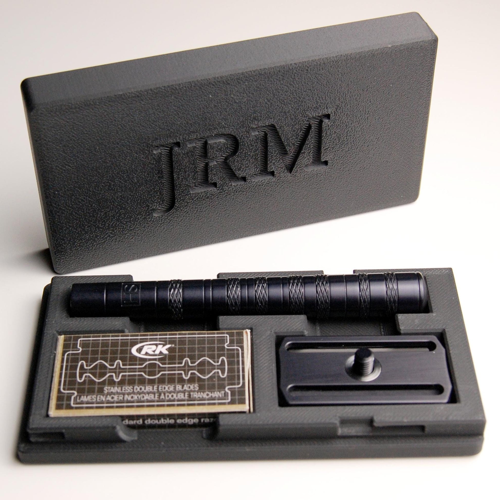 Sophisticated personalized black Henson razor case on a white background.  The letters "JRM" are  on the case lid.  The razor and spare blades are in the case.