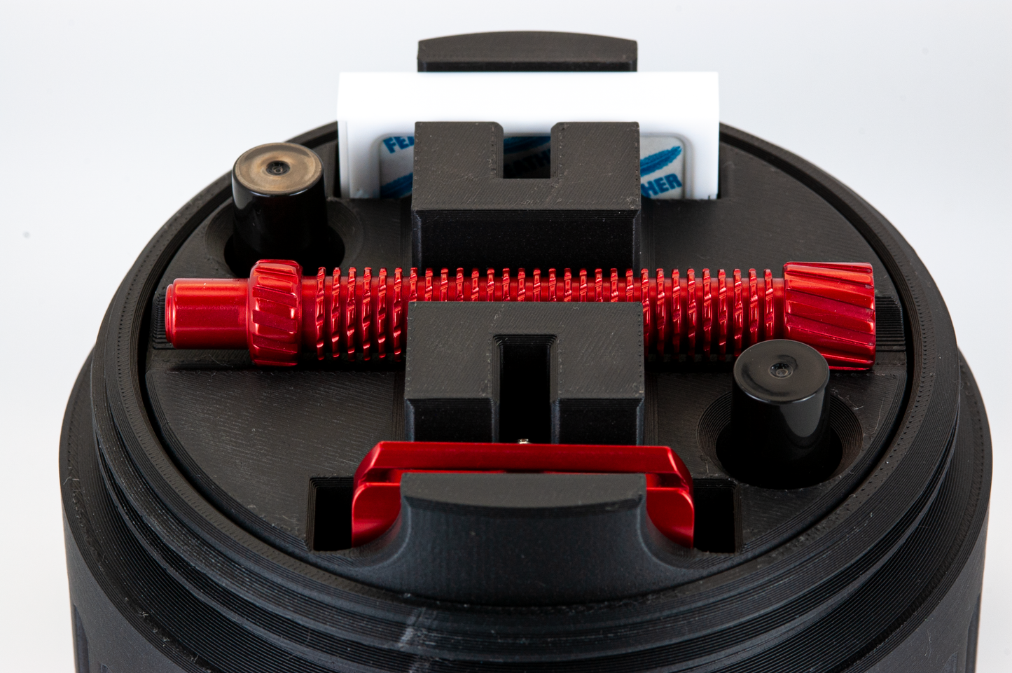 Closeup of the UFO insert showing a red razor, two atomizers, and a pack of feather blades stored in the insert.