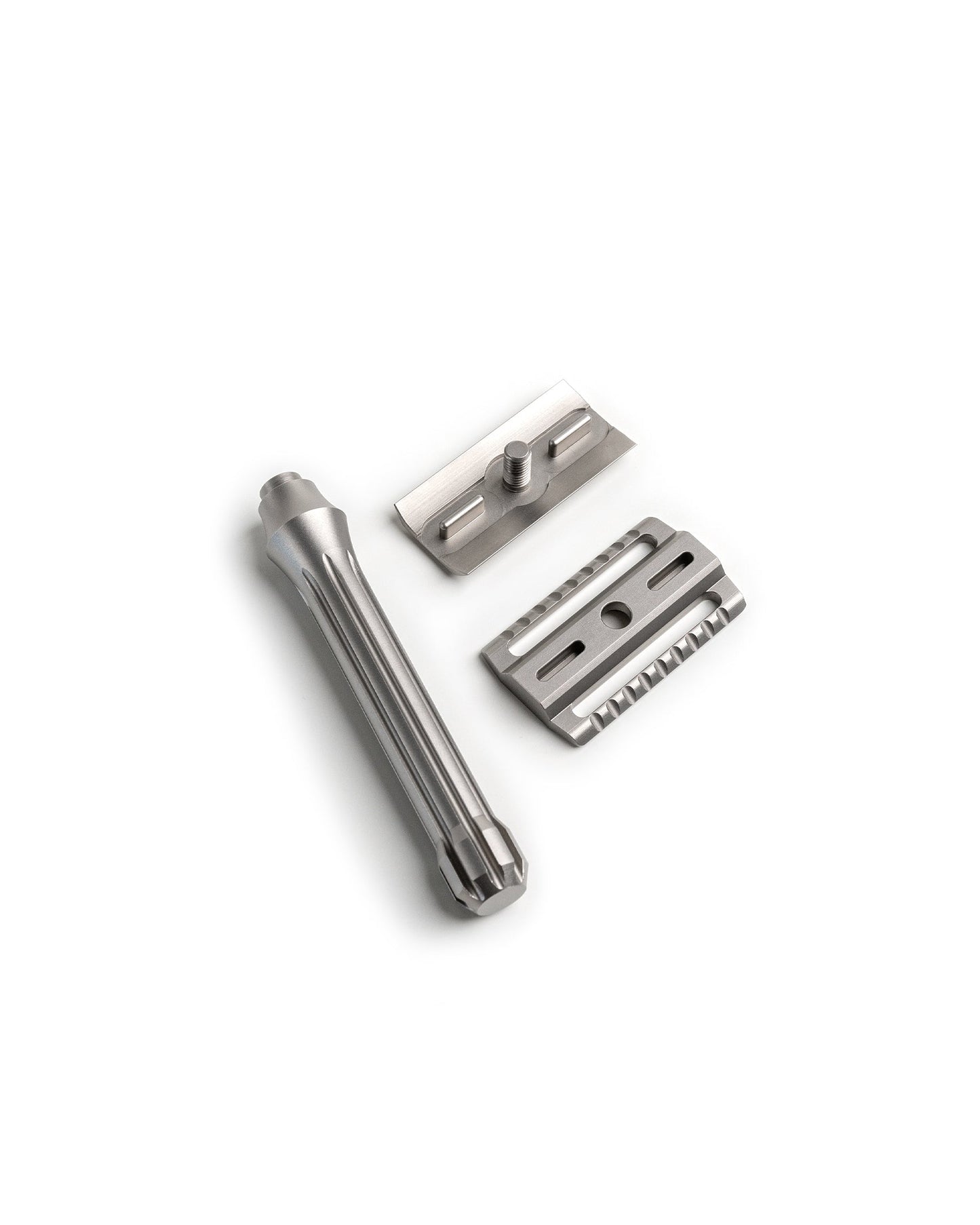 Disassembled Blackbird Titanium safety razor showing three parts: fluted handle, top cap with threaded post, and base plate