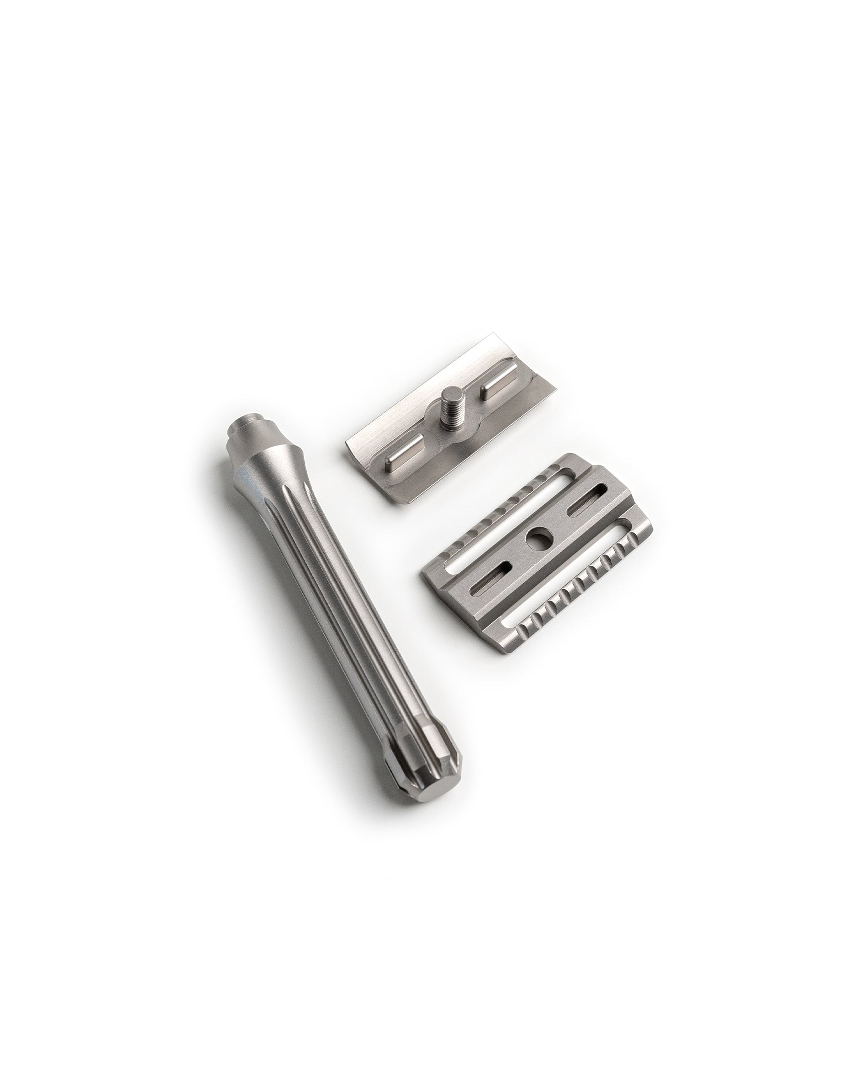 Disassembled Blackbird Titanium safety razor showing three parts: fluted handle, top cap with threaded post, and base plate