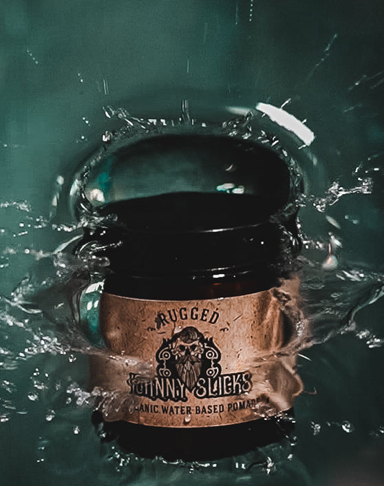 Johnny Slicks Rugged Organic Water Based Pomade in amber glass jar with black lid, splashing into teal water