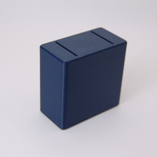 Dark navy blue rectangular box with two slots on top, used as a razor blade bank for safe disposal