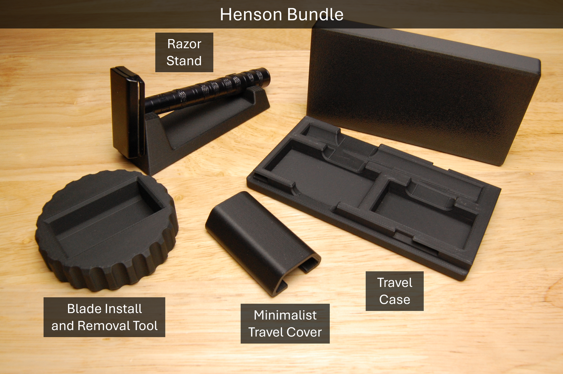 Henson Bundle features a Double Edge Razor Blade Install and removal tool, Henson Razor Stand, Henson Minimalist Travel Cover, and a Henson Travel Case.  All accessories are black and are sitting on a wooden table.