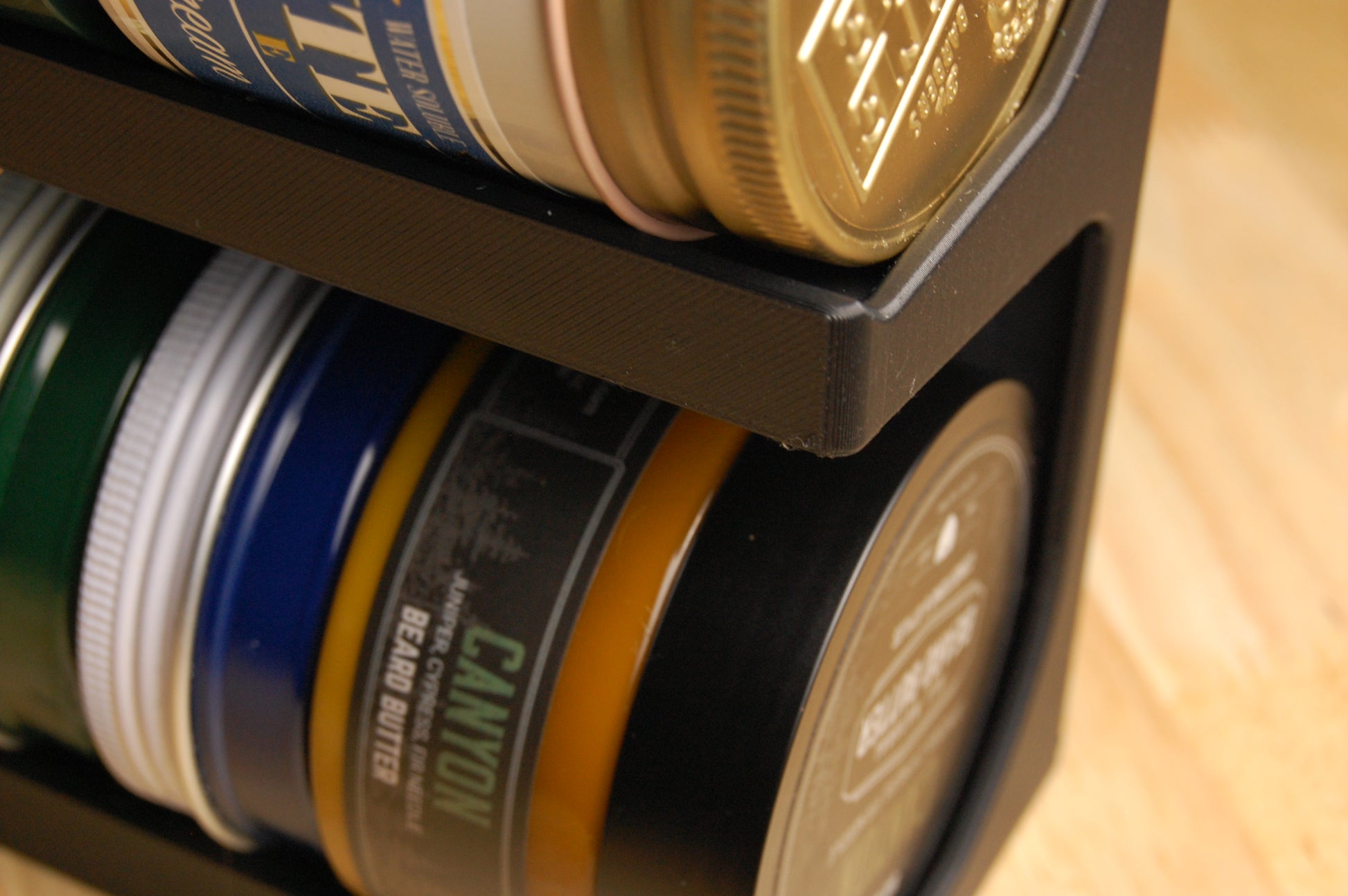 Collection of beard butter containers in a storage rack.