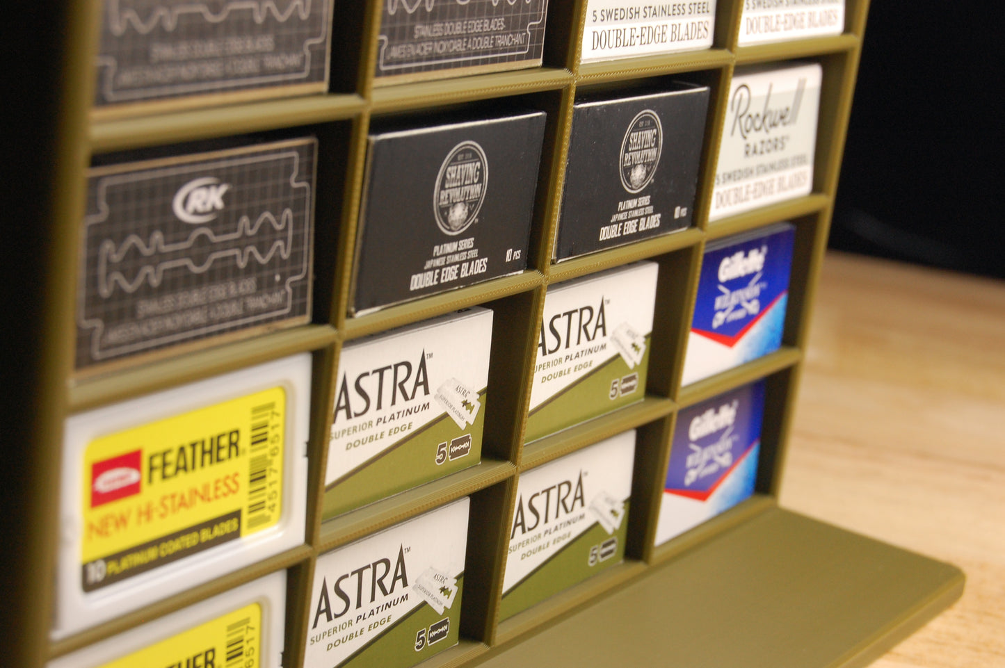 Display of various razor blade packaging with brand names on a wooden surface.