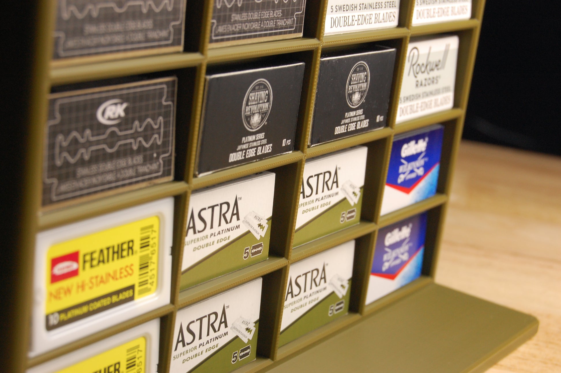 Display of various razor blade packaging with brand names on a wooden surface.