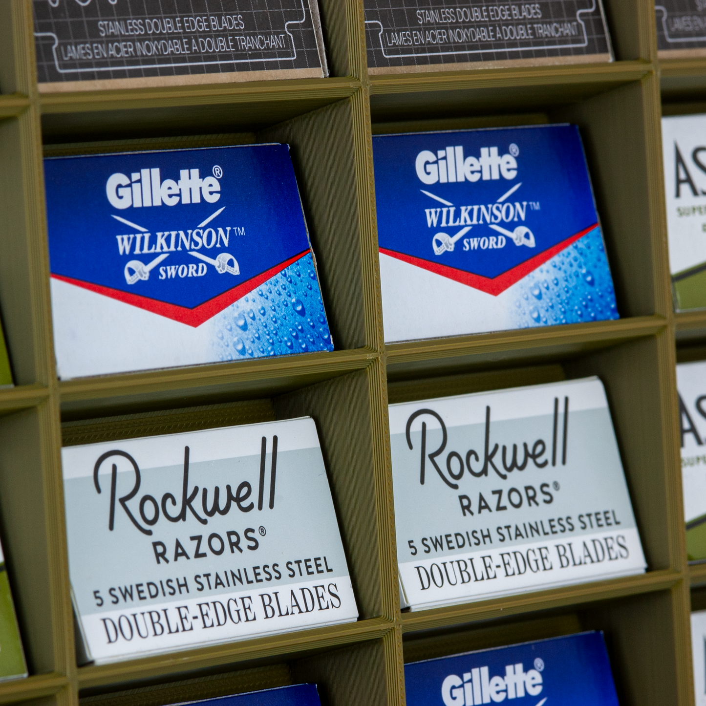 Army green razor blade stand on white background with Astra, Rockwell, RK, and Gillette Wilkinson blades displayed