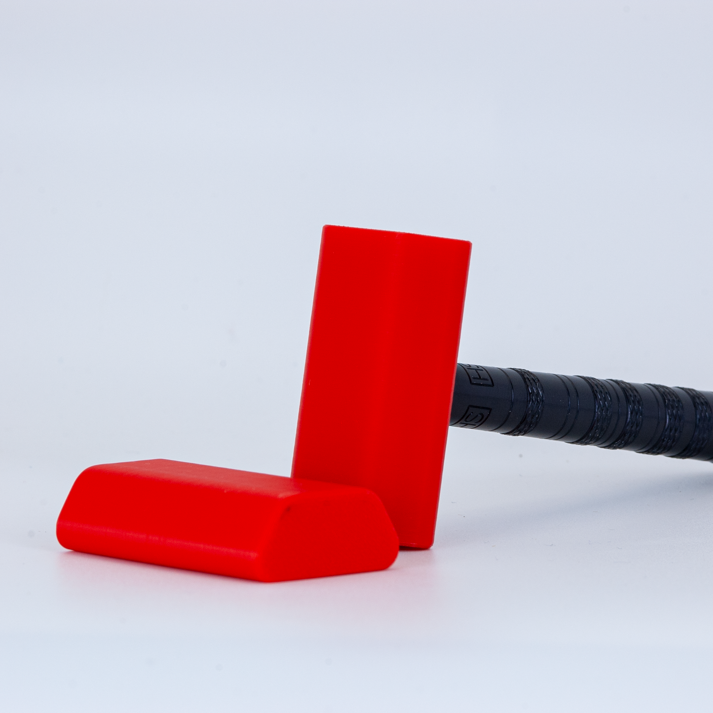 Red Henson cover on a black henson razor on a white background