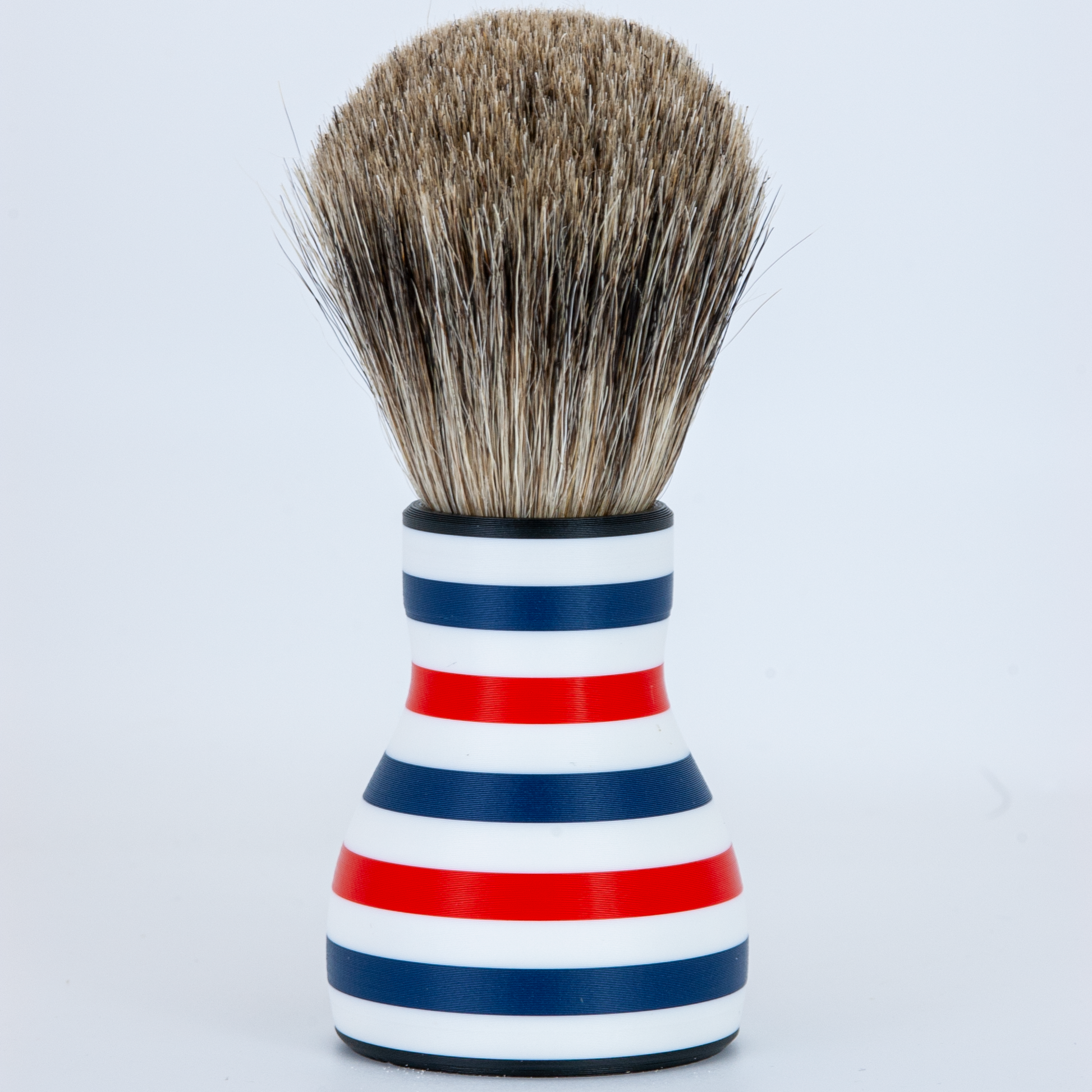 Shaving brush with a striped handle on a white background