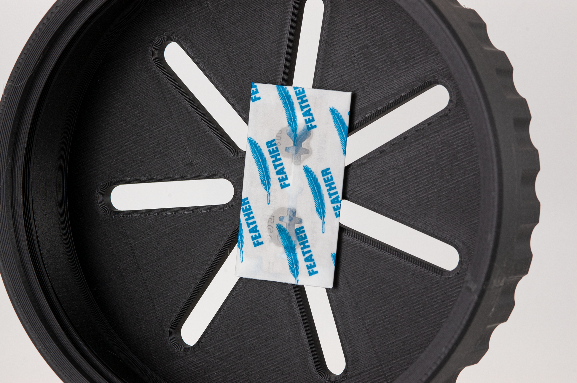 Feather Blade attached by a magnet to a black UFO lid