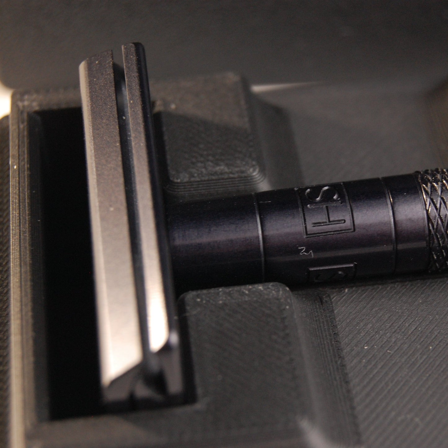 Black universal case with a black Henson AL13. Two feather blade boxes are stored alongside the razor.