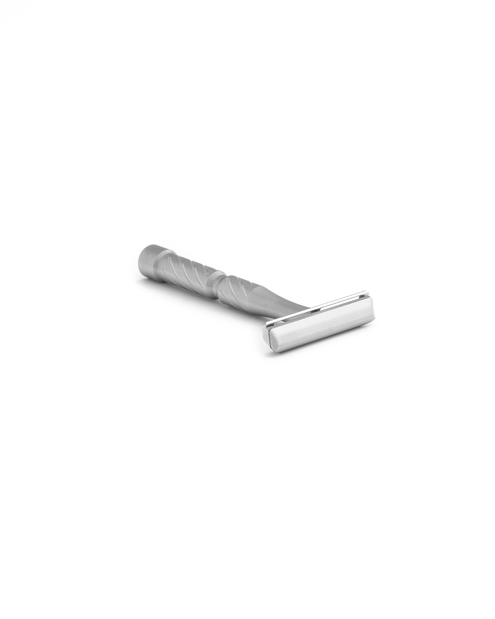 Stainless steel double-edge safety razor with spiral-textured handle, matte finish, lying on white background