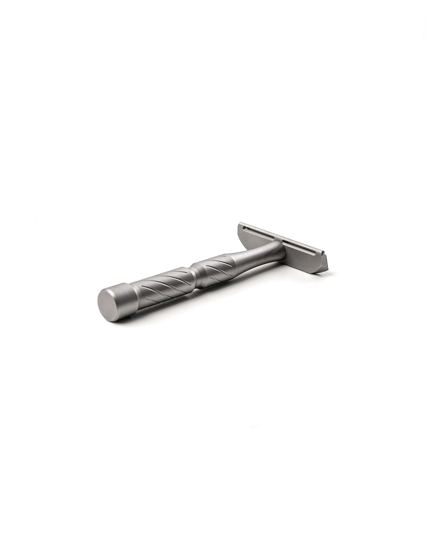 Silver titanium double-edge safety razor with diagonal-grooved handle, lying on white background
