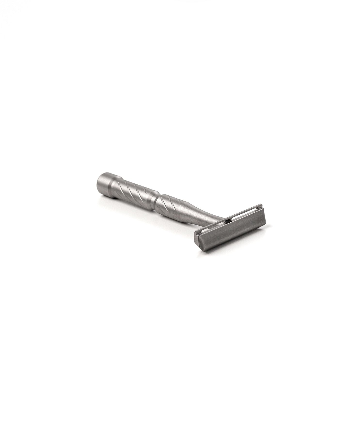 Vector Titanium double-edge safety razor with spiral-textured handle and matte silver finish, lying on its side