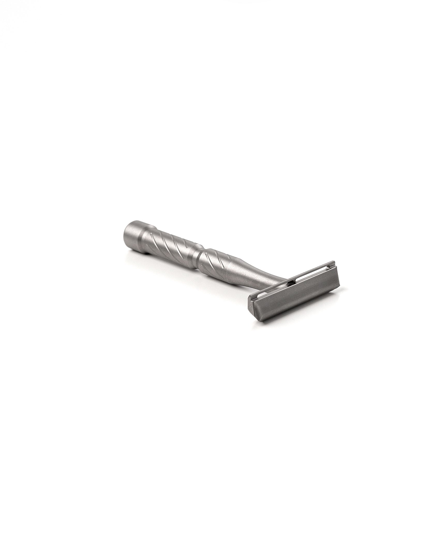 Vector Titanium double-edge safety razor with spiral-textured handle and matte silver finish, lying on its side