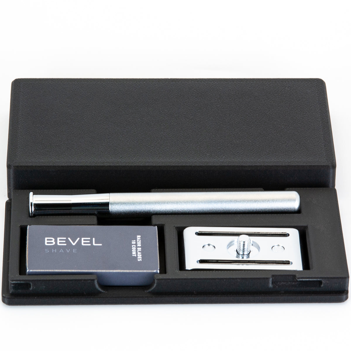 Bevel razor travel case shown open at an angle with silver safety razor handle, Bevel blades box, and chrome baseplate inside