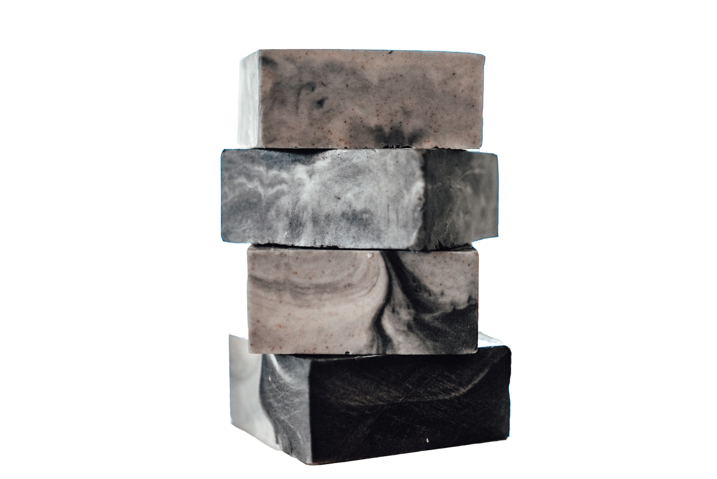 Stack of four handmade soap bars with black, gray, and white marbled swirl patterns on a white background
