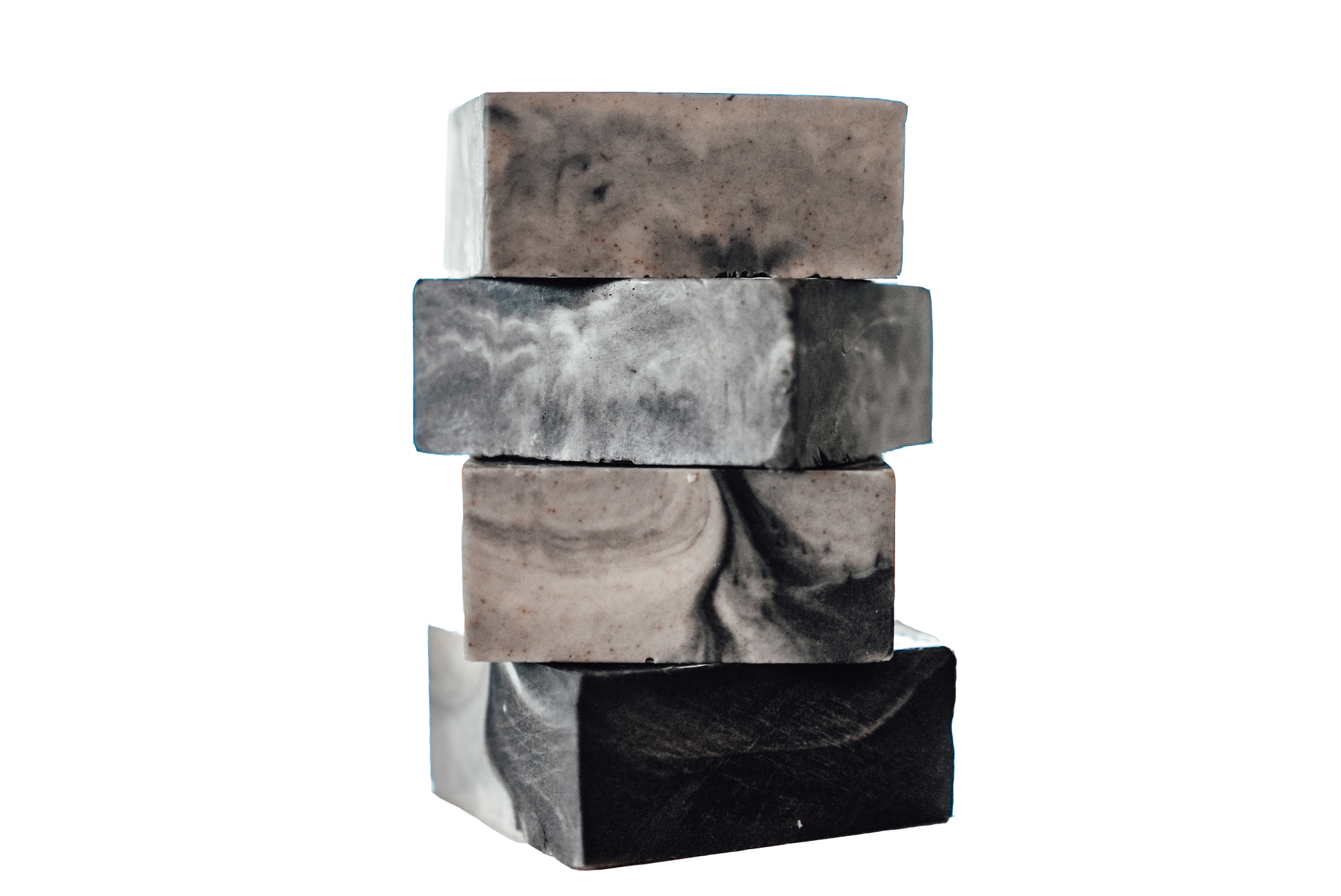 Stack of four handmade soap bars with black, gray, and white marbled swirl patterns on a white background