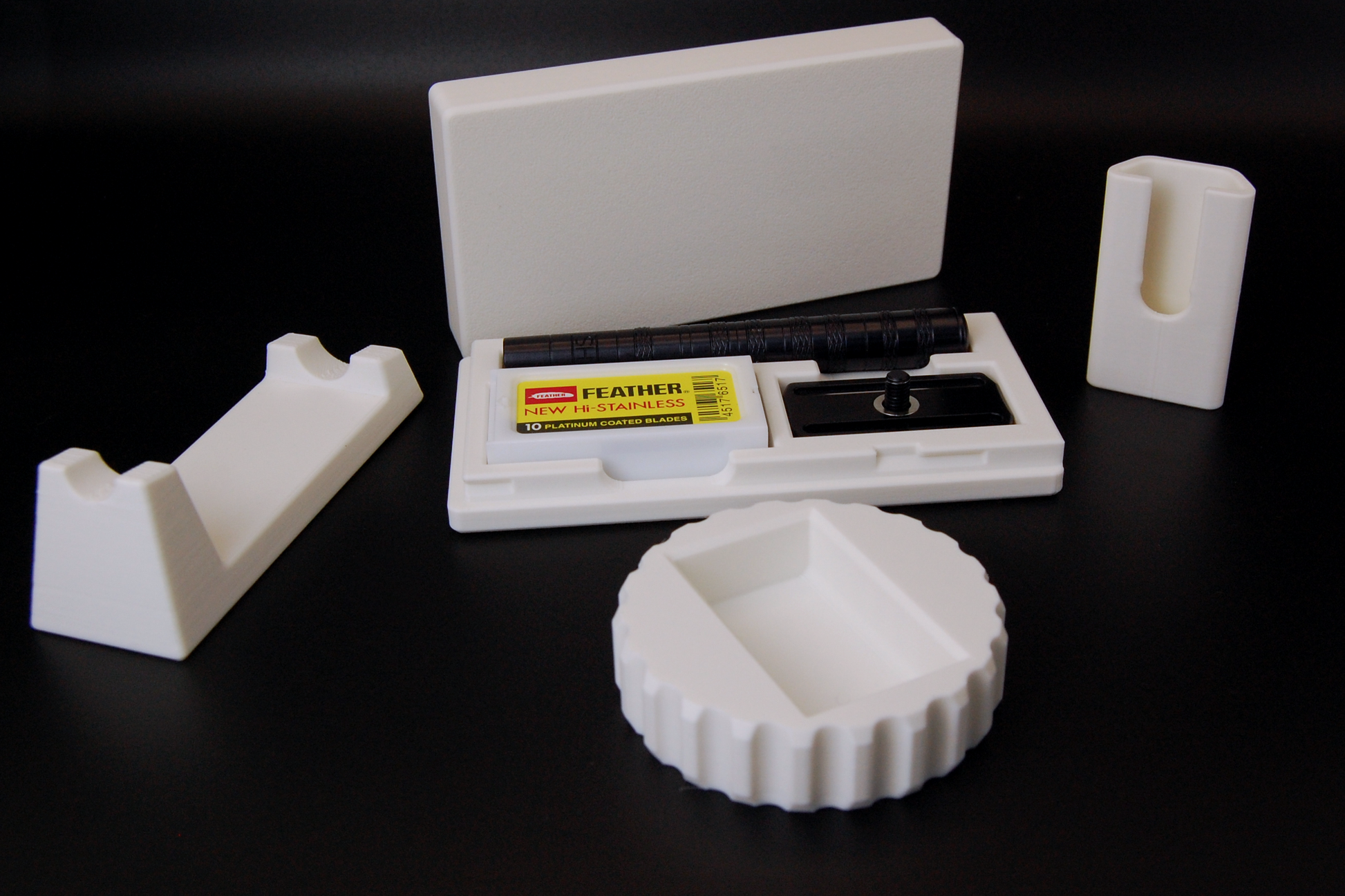Henson razor bundle in white on black background.  Includes Henson Case, Henson Cover, razor stand, razor refueler.