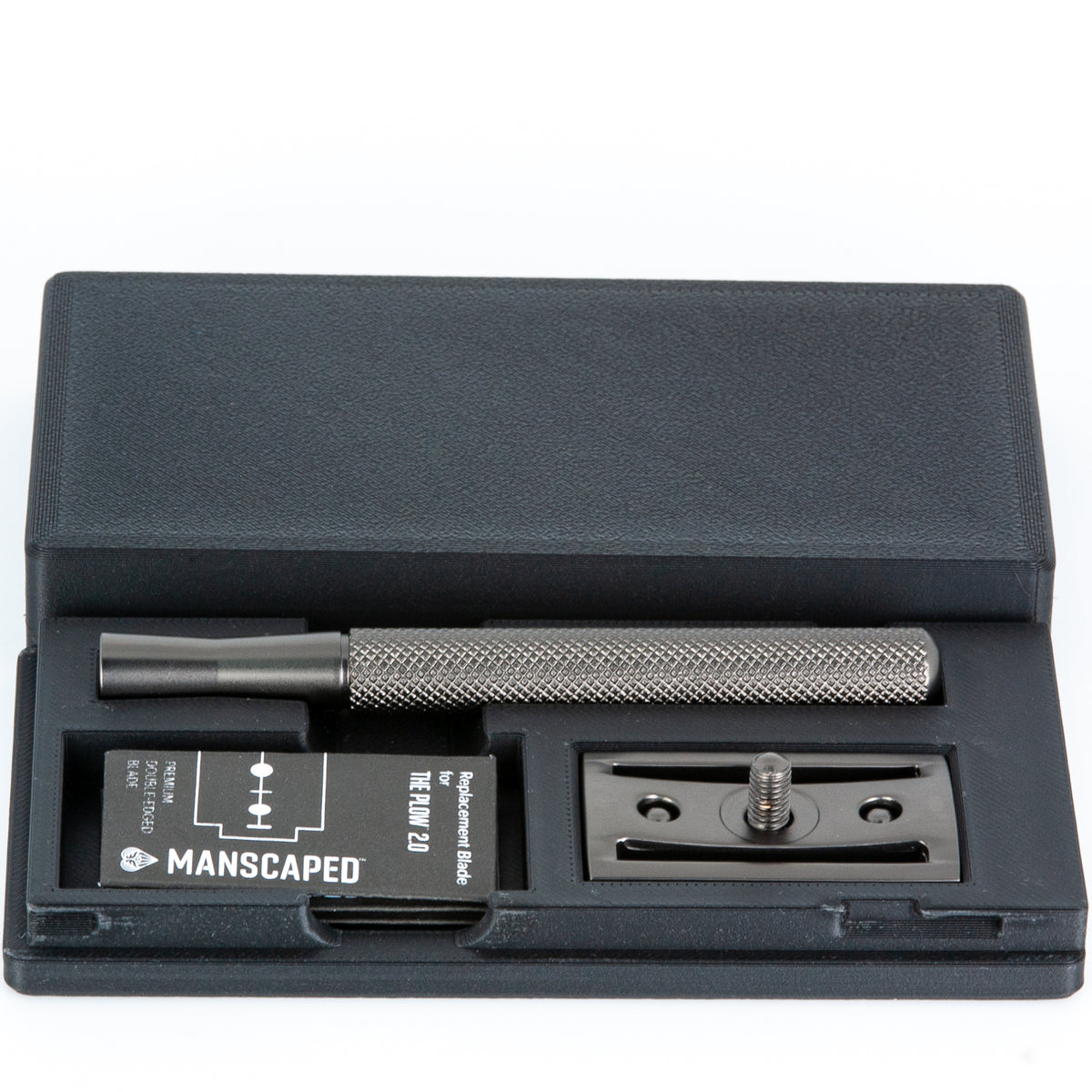 Manscaped Plow 2.0 razor travel case open at an angle showing the razor handle, blade box, and baseplate