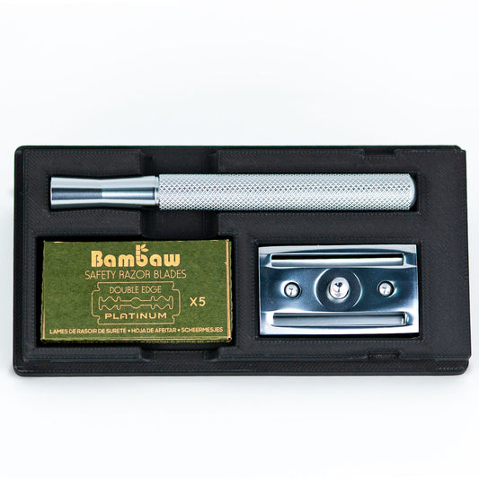 Open black Bambaw razor travel case with chrome safety razor handle, box of Bambaw safety razor blades, and chrome baseplate