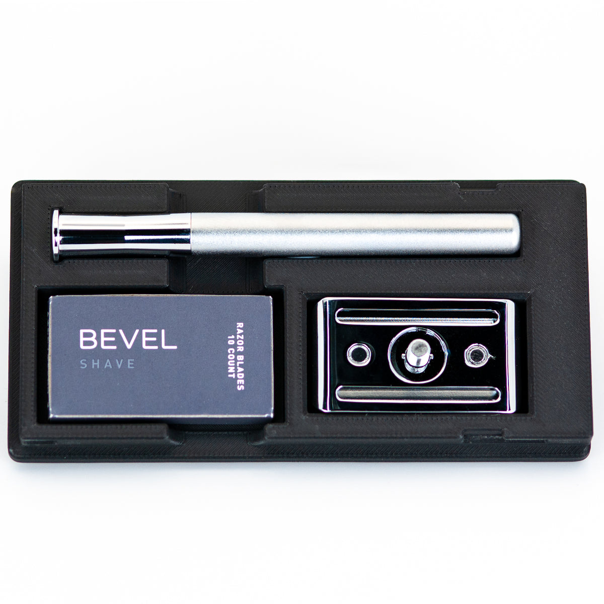 Open black Bevel razor travel case with silver safety razor handle, box of Bevel razor blades, and chrome baseplate