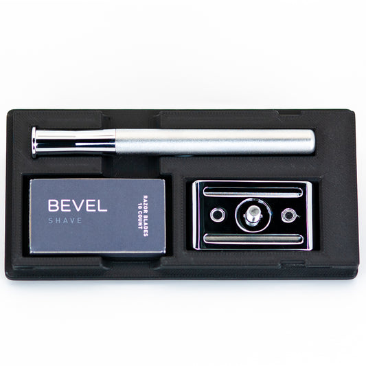 Open black Bevel razor travel case with silver safety razor handle, box of Bevel razor blades, and chrome baseplate
