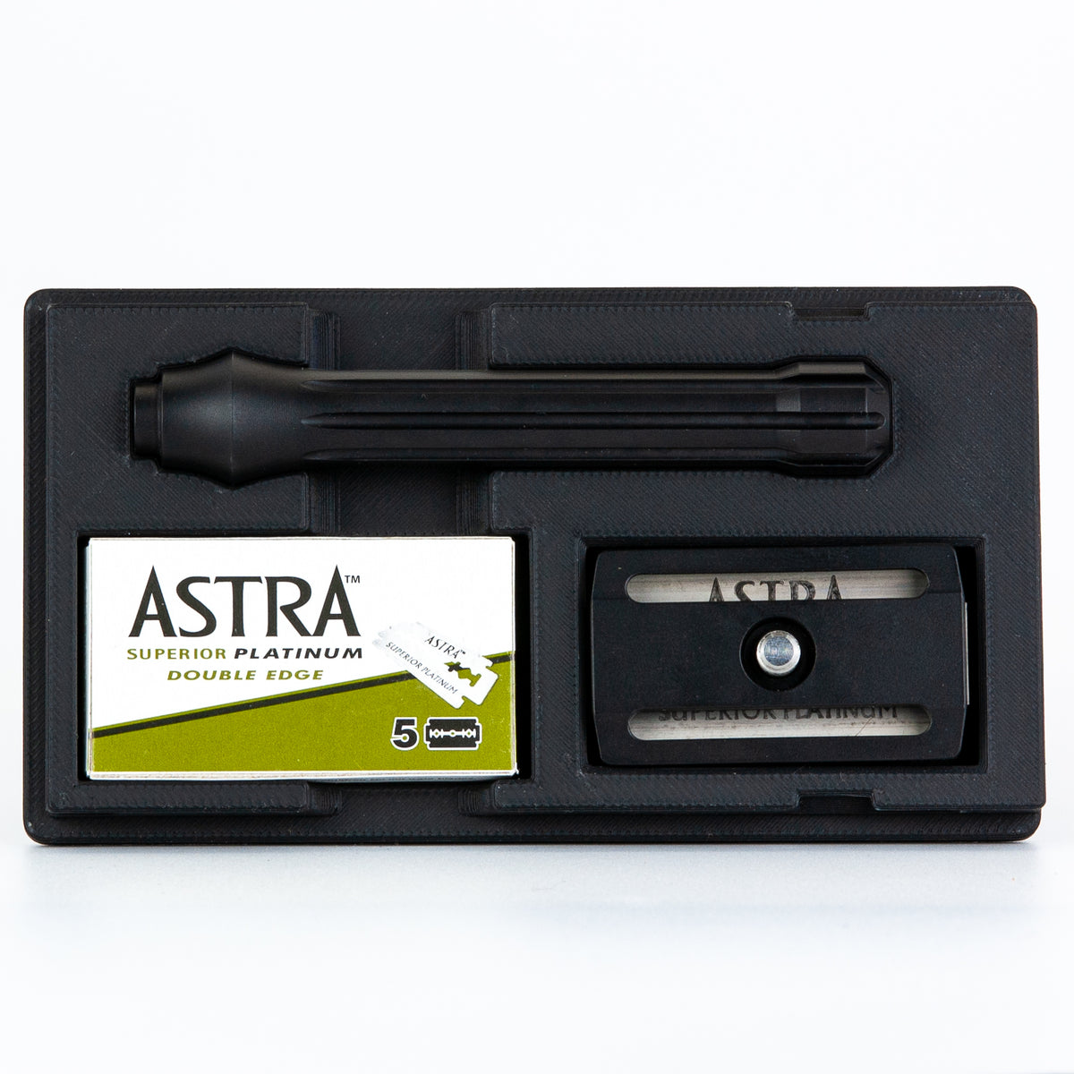 Open black Blackland Blackbird razor travel case with black razor handle, box of Astra Superior Platinum blades, and blade dispenser insert