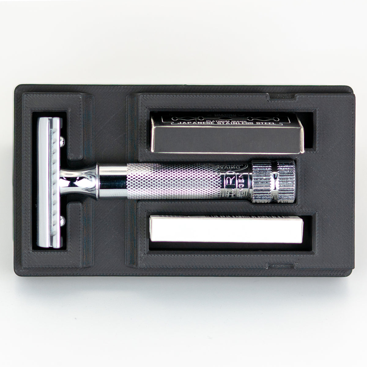 Open Merkur 34C safety razor travel case with chrome butterfly-style razor handle, box of Astra blades, and chrome baseplate