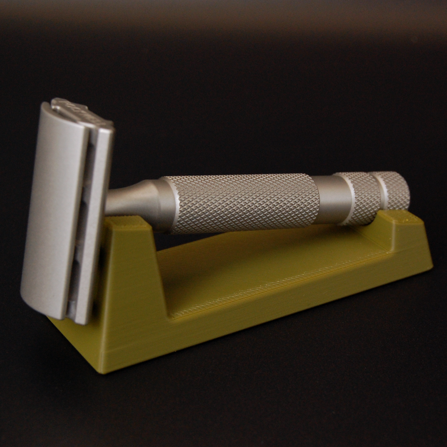Universal razor stand in army green on a black background.  Pictured with a Rockwell 6S razor.